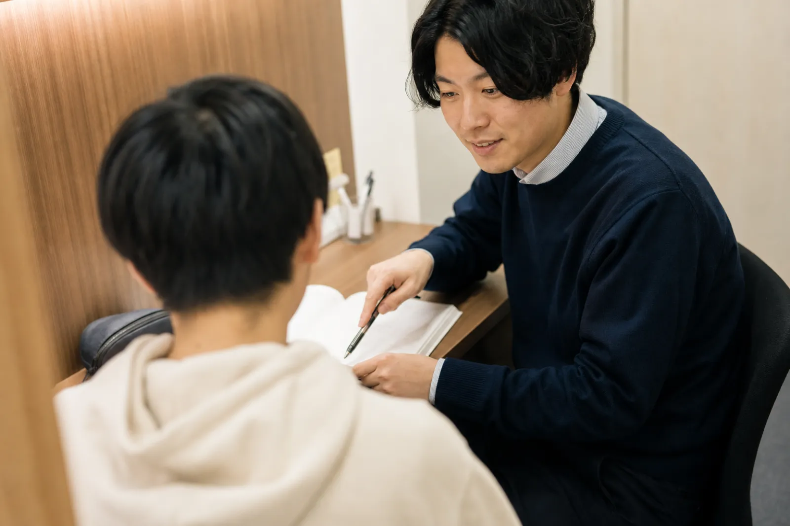 個別指導ブースで生徒に説明する講師